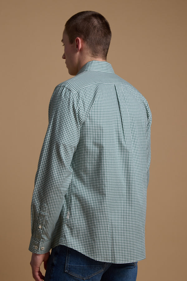A young man with short brown hair, seen from behind, wears a Barkers Courtland Check Shirt in light green and white, made from responsibly sourced cotton, paired with blue jeans against a plain beige background.