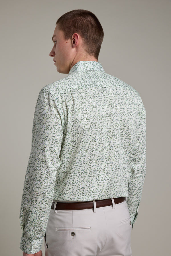 A man faces away, displaying the back of his Barkers Ambrose Print Shirt in light green, tailored fit and made from responsibly sourced cotton, paired with white pants and a brown belt against a plain light background.