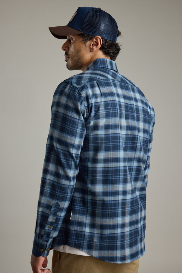 Man in a Barkers Lexington Check Shirt and dark cap, facing away over his shoulder.