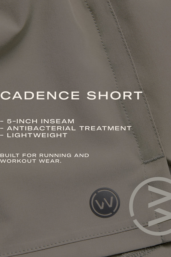 Close-up of gray WearEver Cadence Short with visible stitching. "5-inch inseam, lightweight breathable fabric, antibacterial finish. Designed for running and workouts." WearEver's circular logo shows at the hem.
