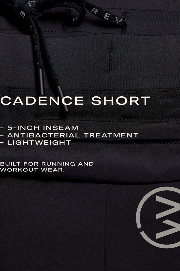 Close-up of WearEver Cadence Short running shorts in black with drawstrings, 5-inch inseam, antibacterial finish, and lightweight design—ideal for training or running. WearEver circular logo is featured at the bottom right corner.