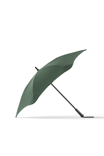 The Blunt Classic Umbrella by Blunt in green features a black handle and provides stylish rain protection. Its sleek design stands out against a white background, combining durability with modern aesthetics.