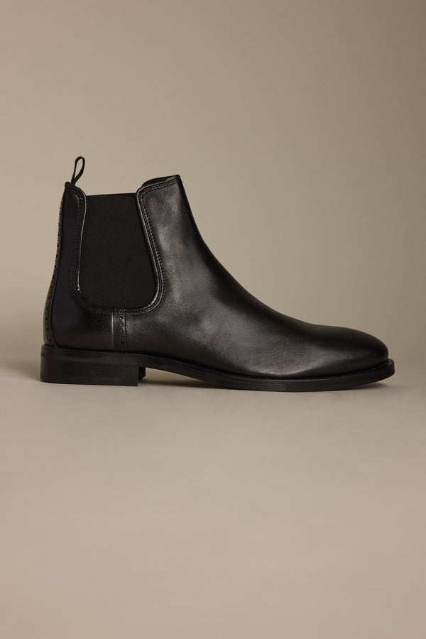 The Peter Chelsea Boot by Barkers is a premium black leather boot featuring an elastic side panel and pull tab, displayed in profile on a neutral background—a stylish showcase of Portuguese craftsmanship.