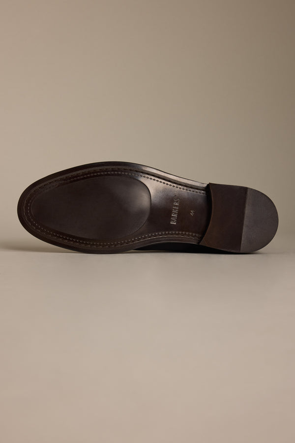 The image shows the sole of the Barkers Peter Chelsea Boot in dark brown, lying flat on a light surface with the sole facing up, highlighting edge stitching details.