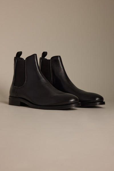 The Peter Chelsea Boot by Barkers, crafted from premium leather with elastic side panels and pull tabs, is showcased on a light beige surface against a matching background.