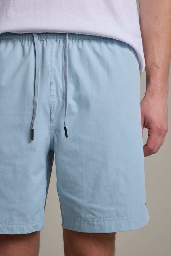 A person wearing Barkers Davis Weekend Short in light blue and a white shirt is shown from the waist to mid-thigh, with one arm visible at their side.