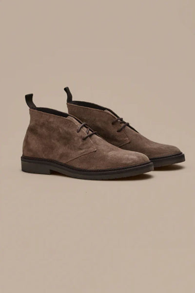 The Barkers Howarth Desert Boot is a pair of brown suede Portuguese footwear with black soles and laces, shown against a plain beige background.