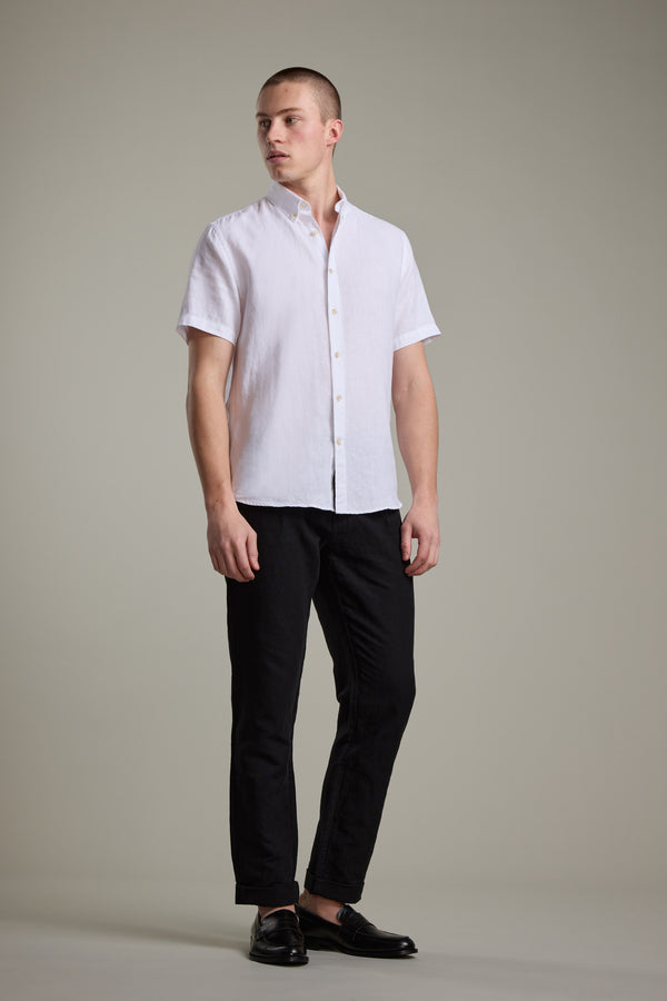 Man wearing Barkers Gentry Linen Shirt in white, black pants, and black shoes, standing upright.