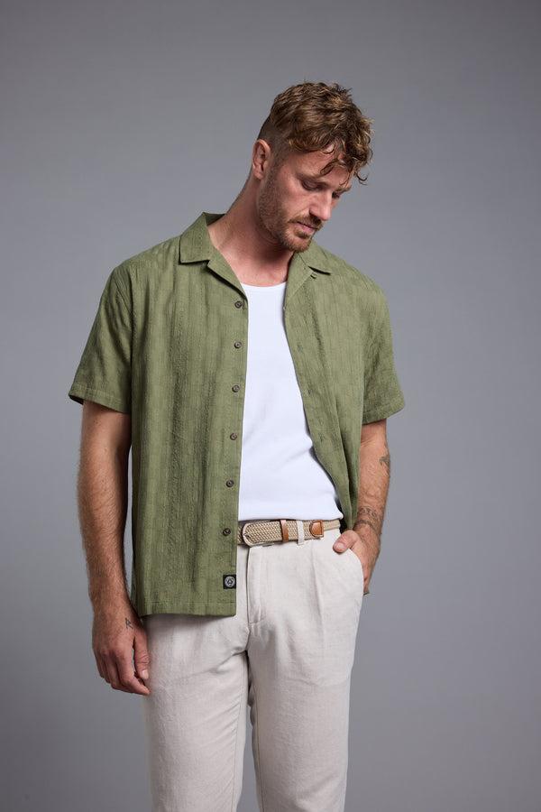 Man in Barkers Otis Stripe Cuban Shirt, white tee, beige pants—your summer essential look.