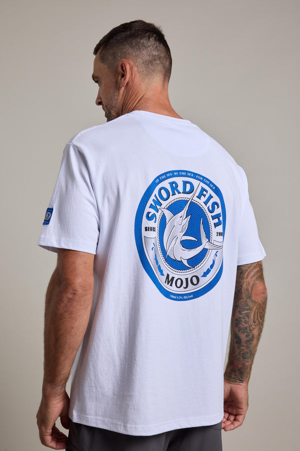 A man with short hair and a tattooed arm wears the Swordfish Mojo Logo Tee by Swordfish Mojo, made from organic cotton, featuring a large blue and gray Swordfish graphic on the back, against a plain background.