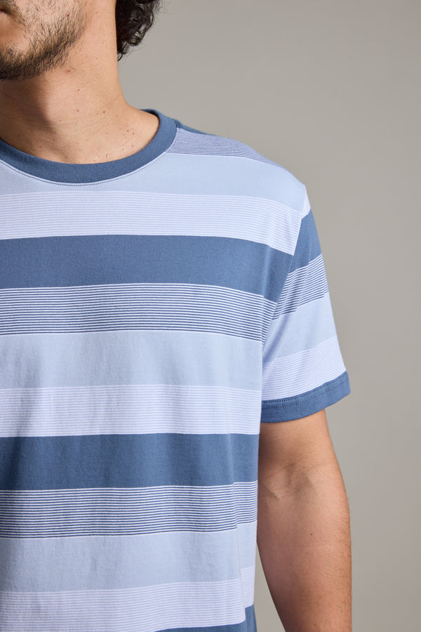 A close-up shows a person in a Barkers Fitzroy Stripe Tee; only the left side of their face and upper body are visible against a plain, neutral background.
