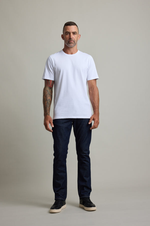 Man with short hair wears Barkers Good Earth Cotton Essential Tee in white and jeans, facing forward.