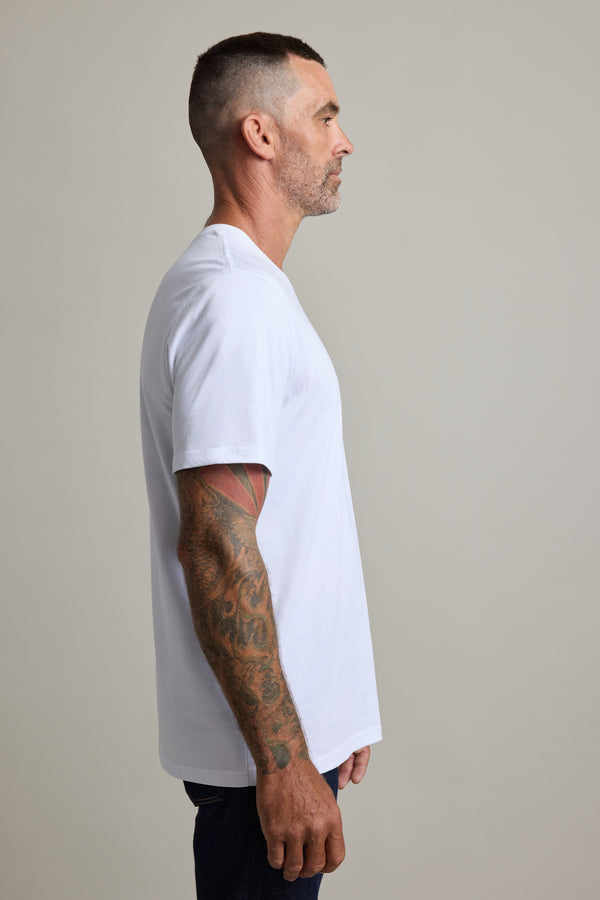Man in Barkers Good Earth Cotton Essential Tee, traceable cotton, tattoos showing, side view.