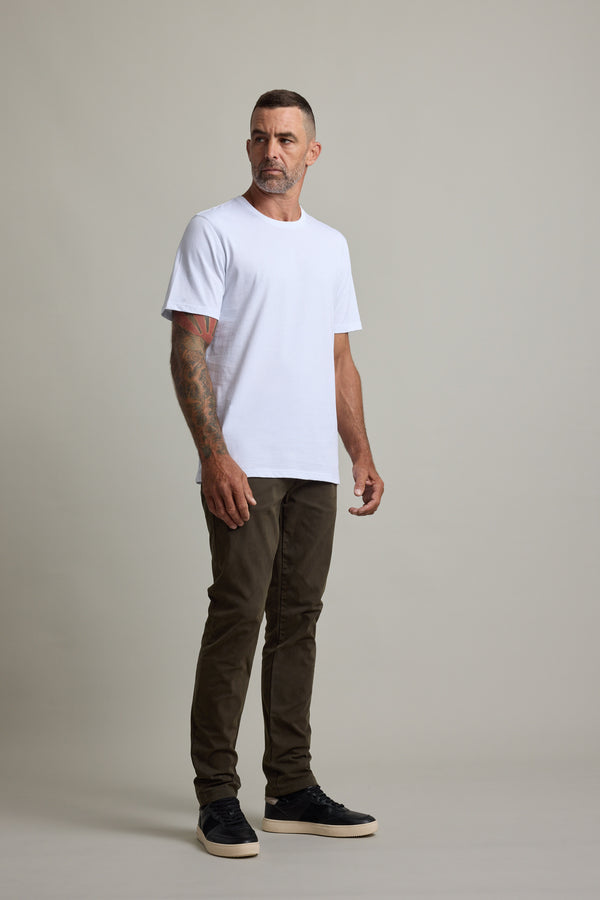 Man in a white Barkers Good Earth Cotton Essential Tee, brown pants, and black shoes.