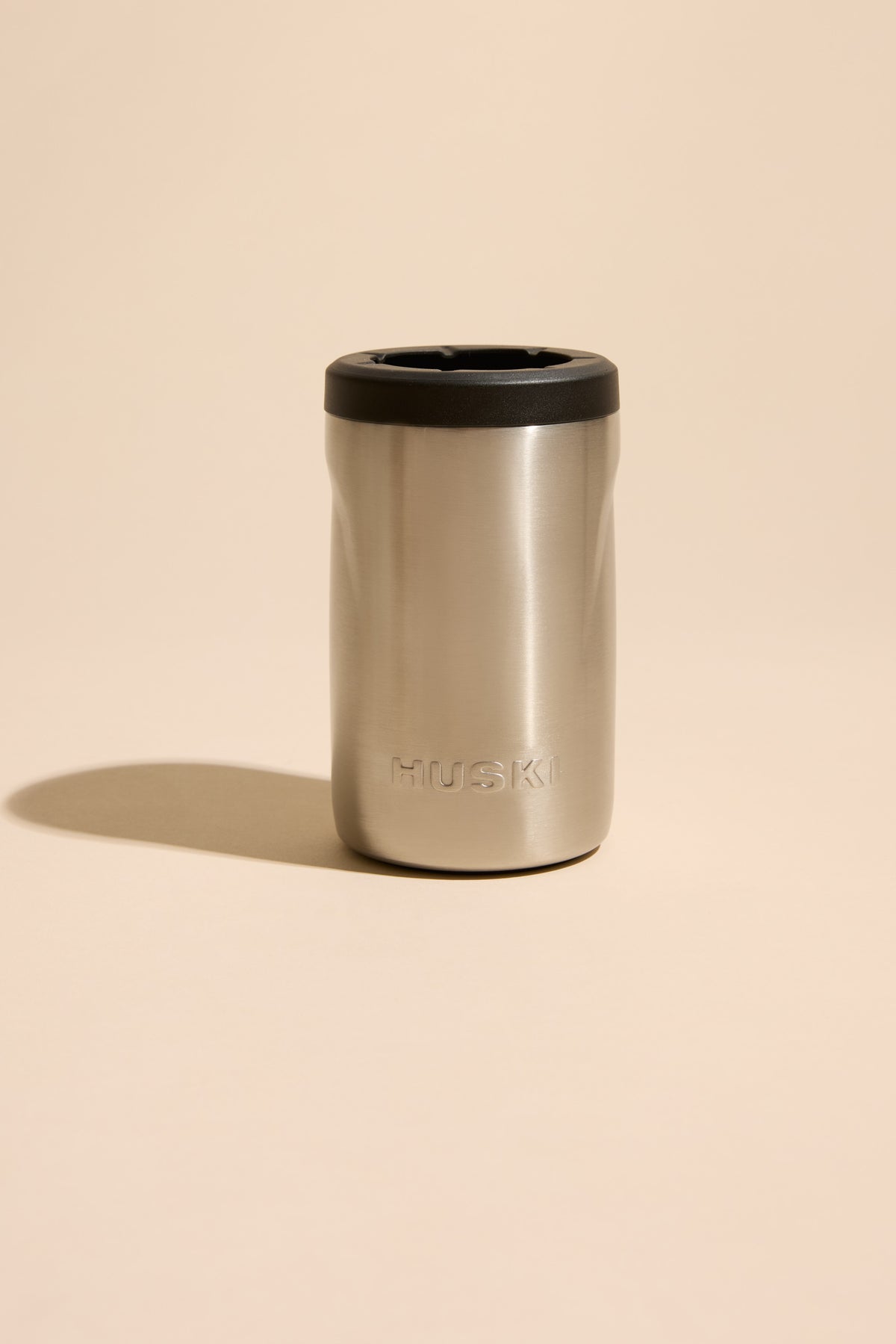 Huski Beer Cooler by Huski on beige keeps your drink cold and stylish.