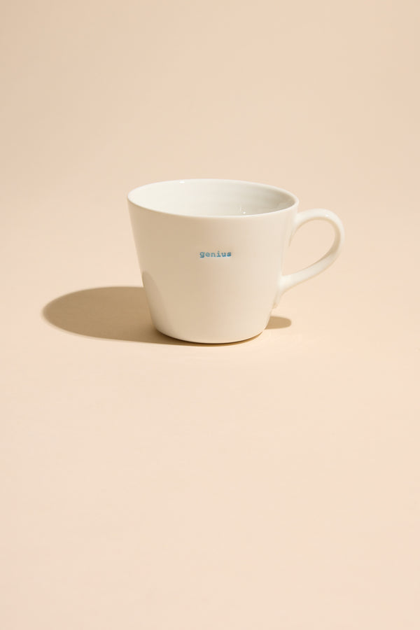 Other Bucket Mug - Genius stands out on a beige background—a bold statement piece for any space.