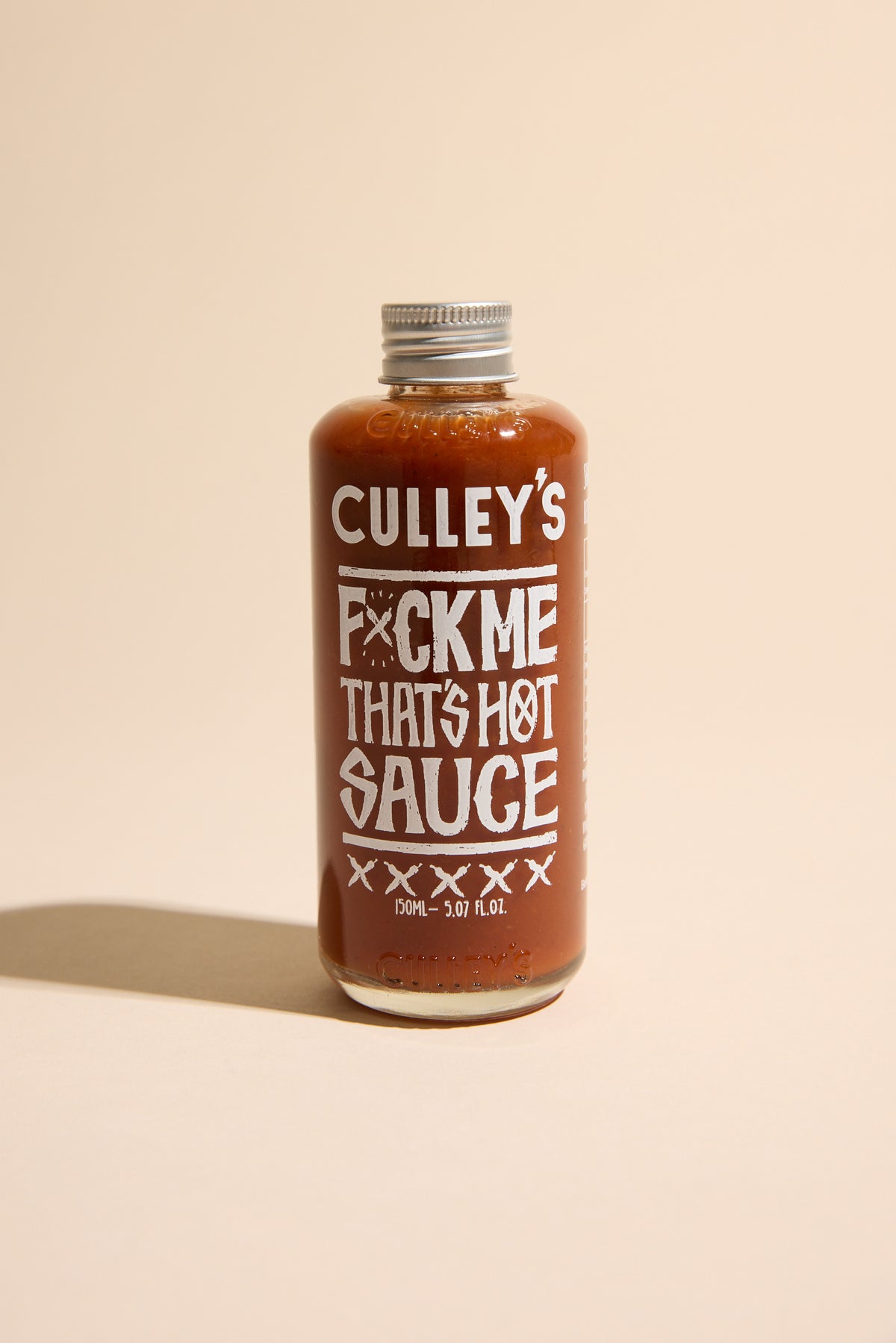 Culley’s F@#k Me That’s Hot Sauce bottle on a beige background.