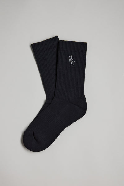 The Barkers BMC Ribbed Sock, in black with a small white BMC logo near the top, is shown in a pair—one placed over the other—on a plain light gray background.