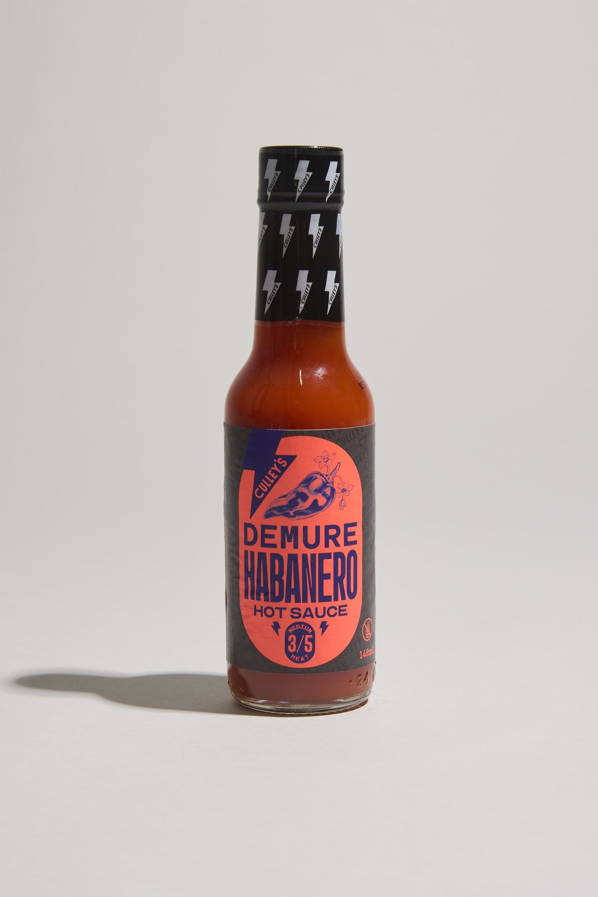 A bottle of Culley’s Demure Habanero Hot Sauce with a black and orange label.