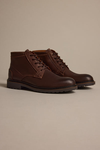 The Barkers Carlton Boot, crafted from dark brown oiled Italian leather with sturdy black soles, is displayed against a neutral beige background.