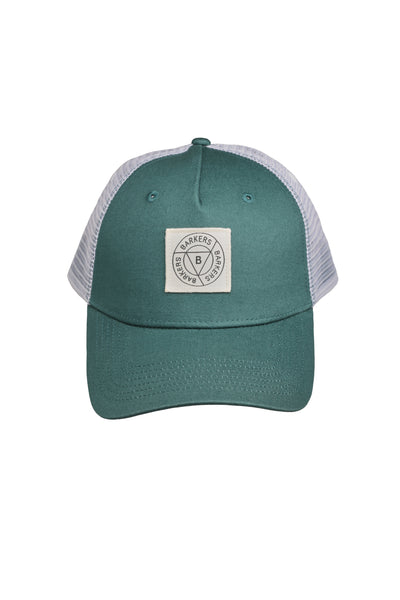 The Barkers Maple Stamp Trucker Cap features green and white colors, a mesh back, and a sewn-on rectangular embroidery patch with the letter B in the center.