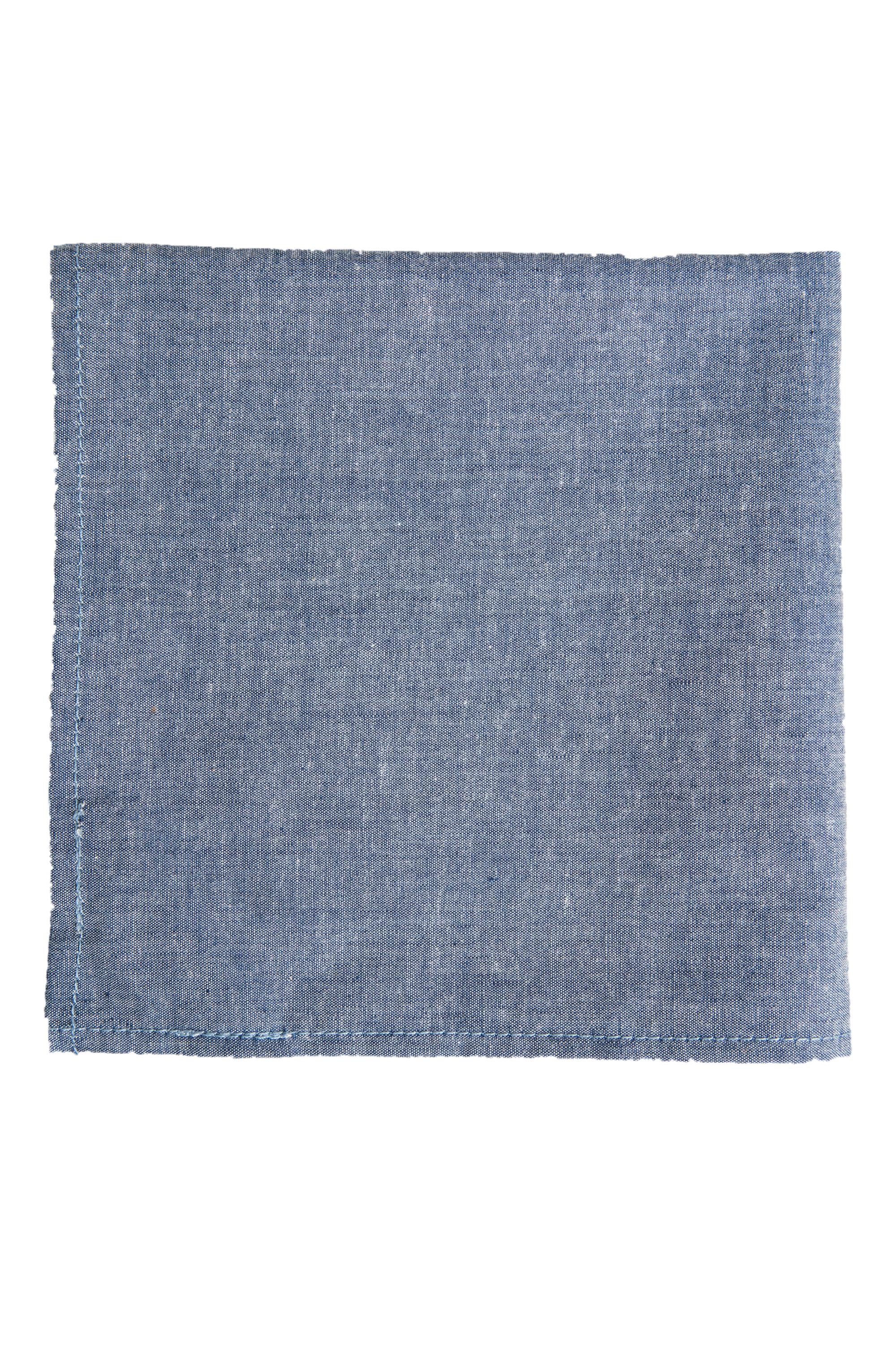 The Parisian Denim Pocket Square by Parisian is a rectangular, blue 100% cotton accessory with subtle texture and visible edge stitching, shown flat on a white background.