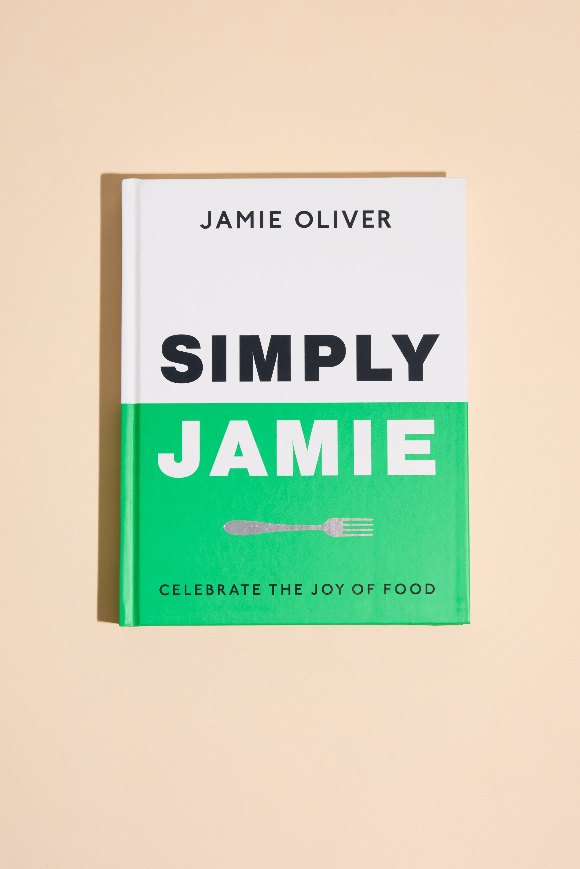 Simply Jamie by Other is a cookbook with a green and white cover, black and white text, a small fork illustration, and the tagline "Celebrate the joy of food"—ideal for easy recipes and quick midweek meals.