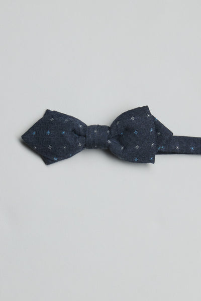 The Parisian Ingram Pattern Bow Tie by Parisian features a dark blue geometric design with light blue and white dots, is handmade in New Zealand, and is displayed flat on a plain light gray background.