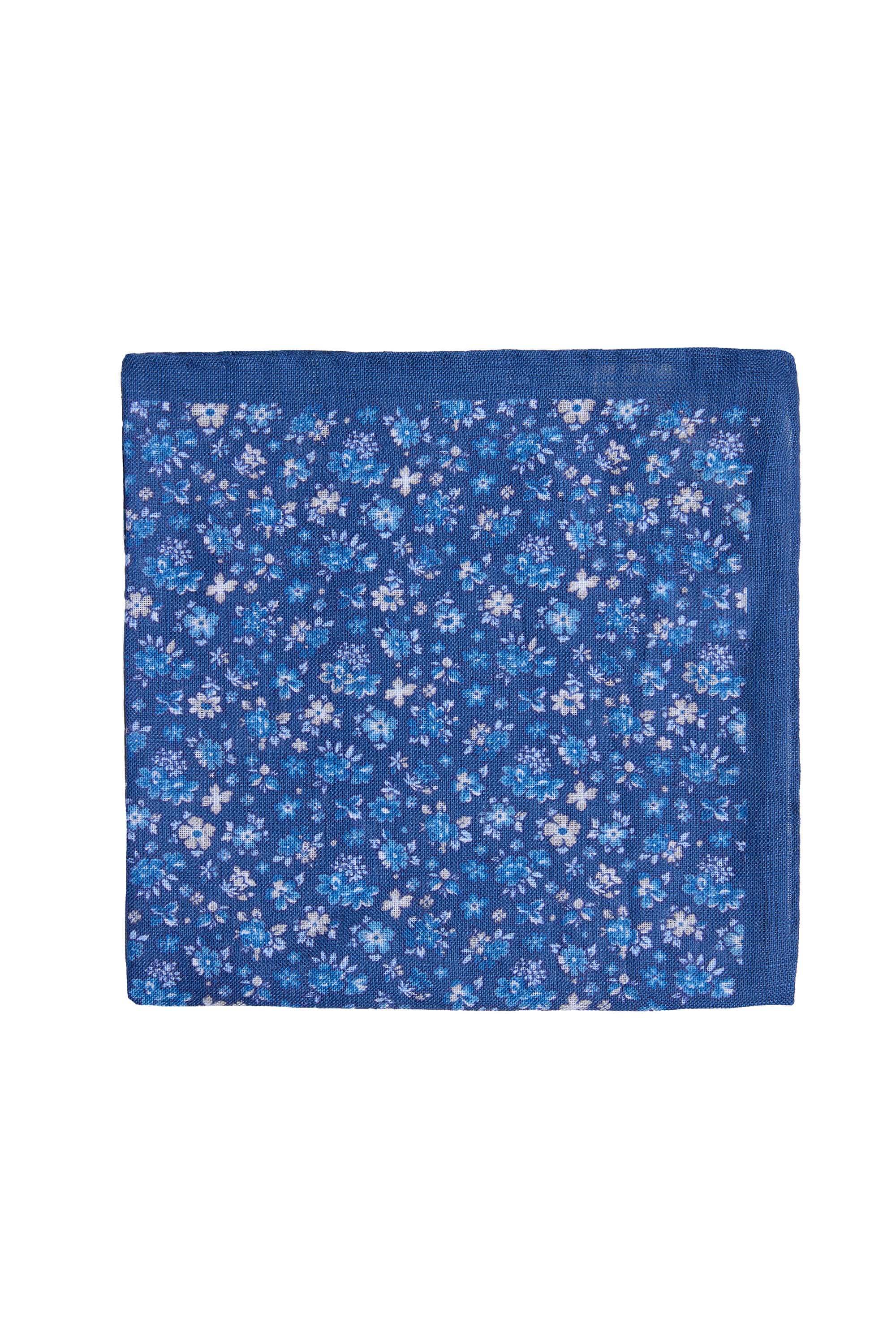 The Parisian Thompson Flower Pocket Square is a blue 100% silk square with a floral print of small white and light blue flowers and a solid blue border, shown laid flat on a white background.