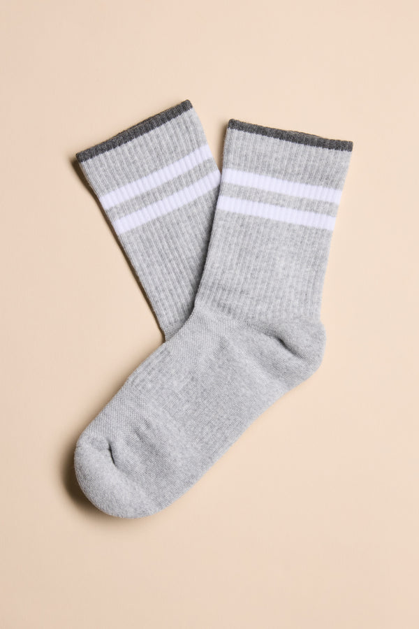 A pair of gray Barkers Emerson Sport Socks with two white stripes and a dark gray cuff, shown flat on a beige surface—perfect crew socks for the gym or daily wear.