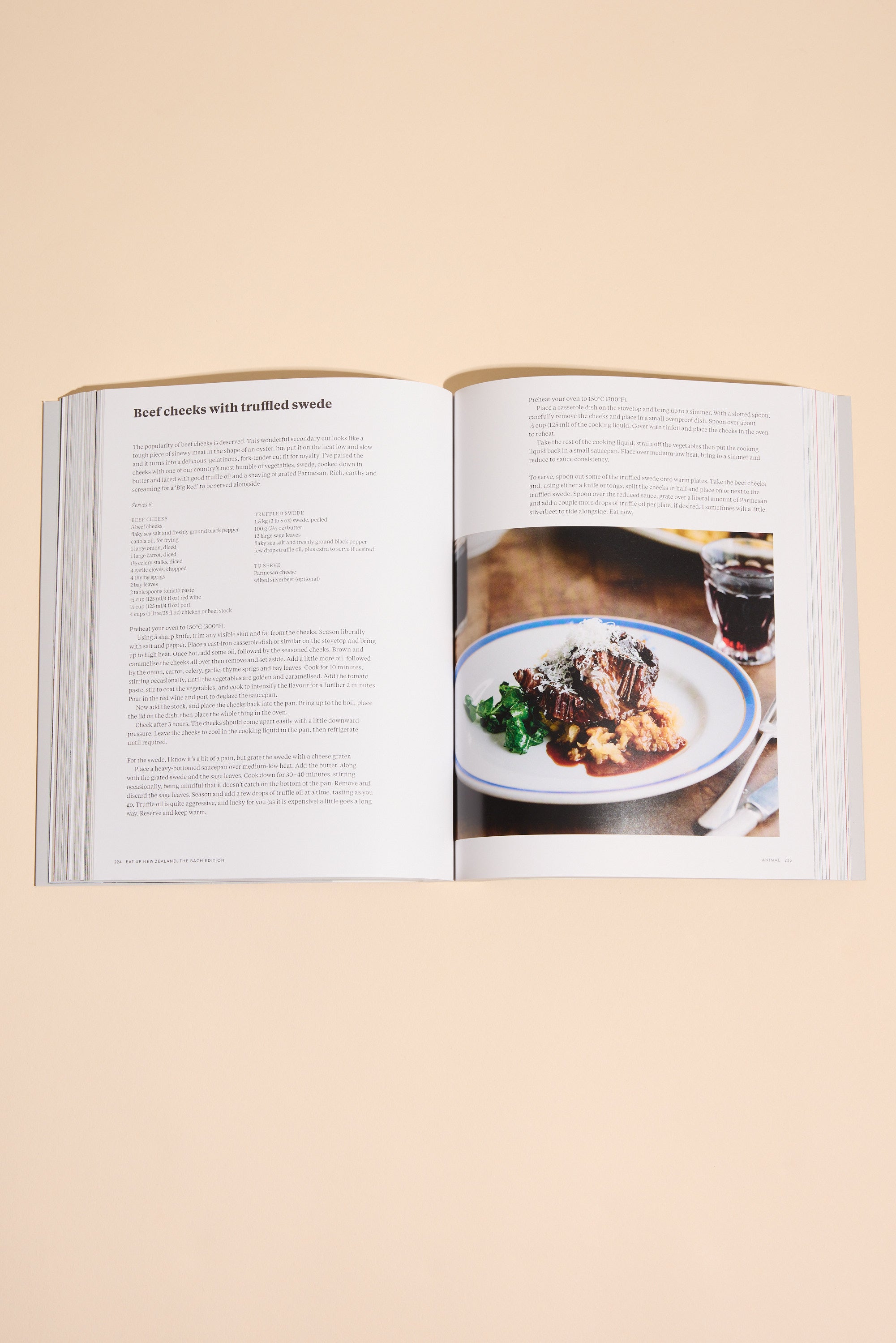 An open Eat Up New Zealand The Bach Edition cookbook by Other shows a recipe and a photo of plated beef with greens and brown sauce on a beige surface—ideal for exploring seasonal New Zealand recipes.