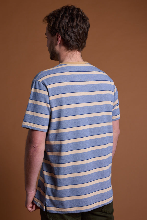 A man with short brown hair, seen from behind, wears the Barkers Chester Stripe Tee—a blue and beige striped men's casual shirt—paired with dark pants, standing against a plain brown background.