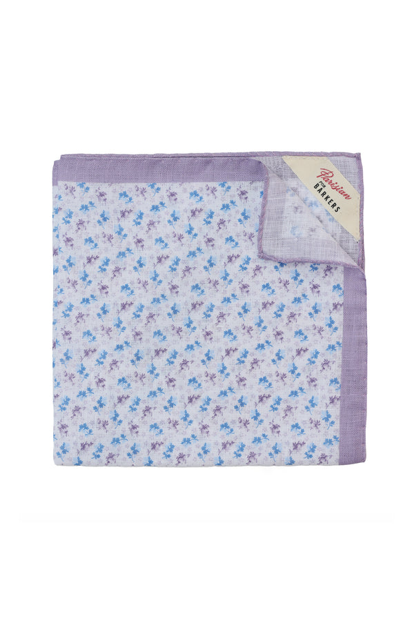 A folded Parisian Ditsy Linen Pocket Square features a purple border with blue and purple floral prints. A "Pattern Handkerchief" label from the Parisian brand is sewn into one corner.