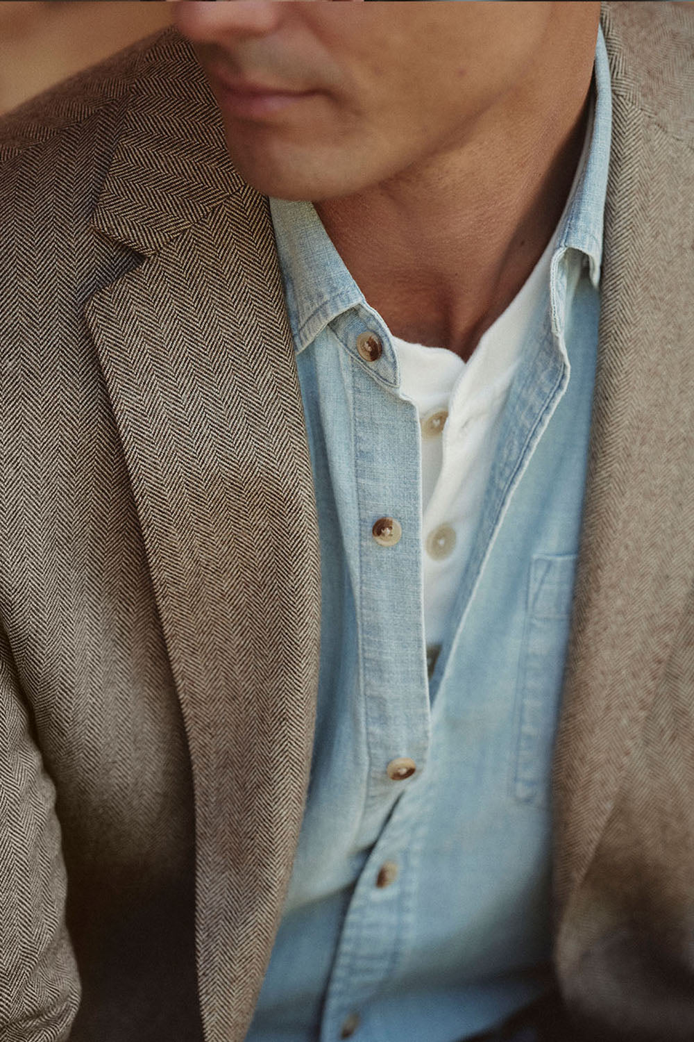 Man wearing a brown blazer, NZ denim shirt, and white t-shirt.