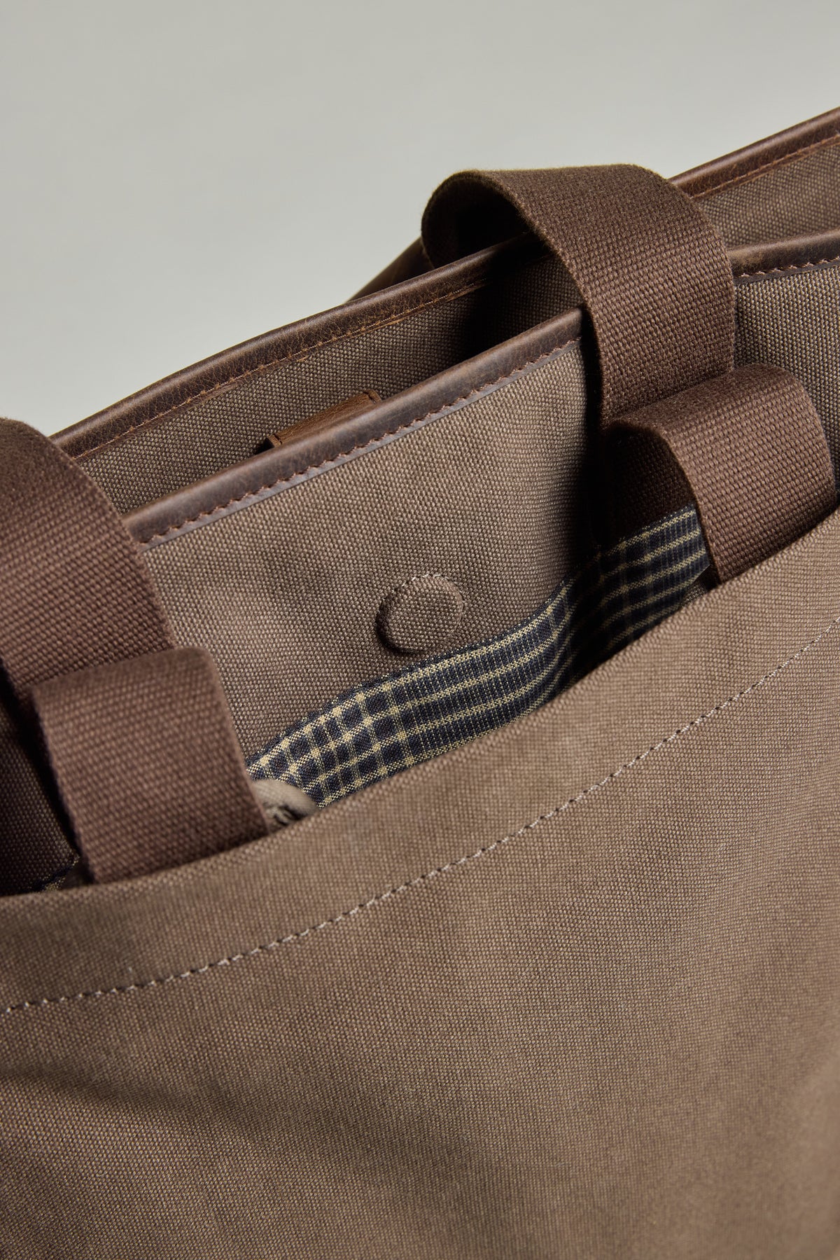 The Barkers Foxton Canvas Convertible Tote has plaid detail and fits a laptop in its outer pocket.