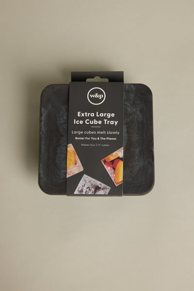 An Ice Tray Sphere Marble Black by Other is shown in its packaging against a beige background. Ideal for your home bar, the label highlights slow-melting ice spheres and features images of drinks with ice and fruit.