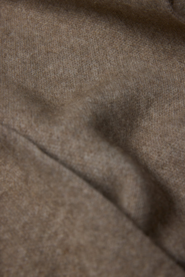 Close-up of the NZ Made Perino Scarf by Woolyarns Perino, showing soft, light brown merino possum silk fabric with a fuzzy texture and gentle folds. Crafted in New Zealand for premium accessories.