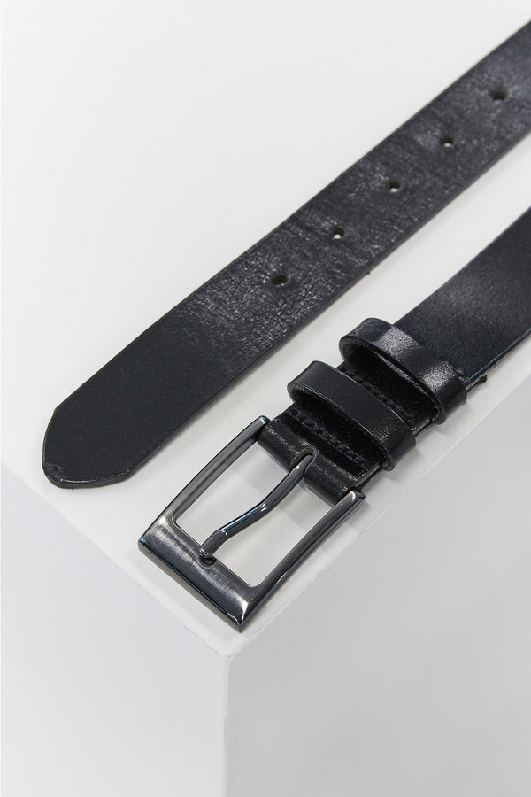 A close-up of the Frances Leather Belt by Barkers, featuring black leather and a silver square buckle, partially unbuckled on a white surface—crafted in New Zealand for timeless style.