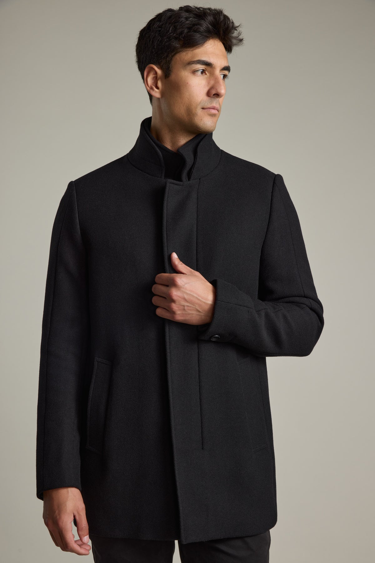 Man in a Barkers Raymond Coat stands sideways against a plain background.