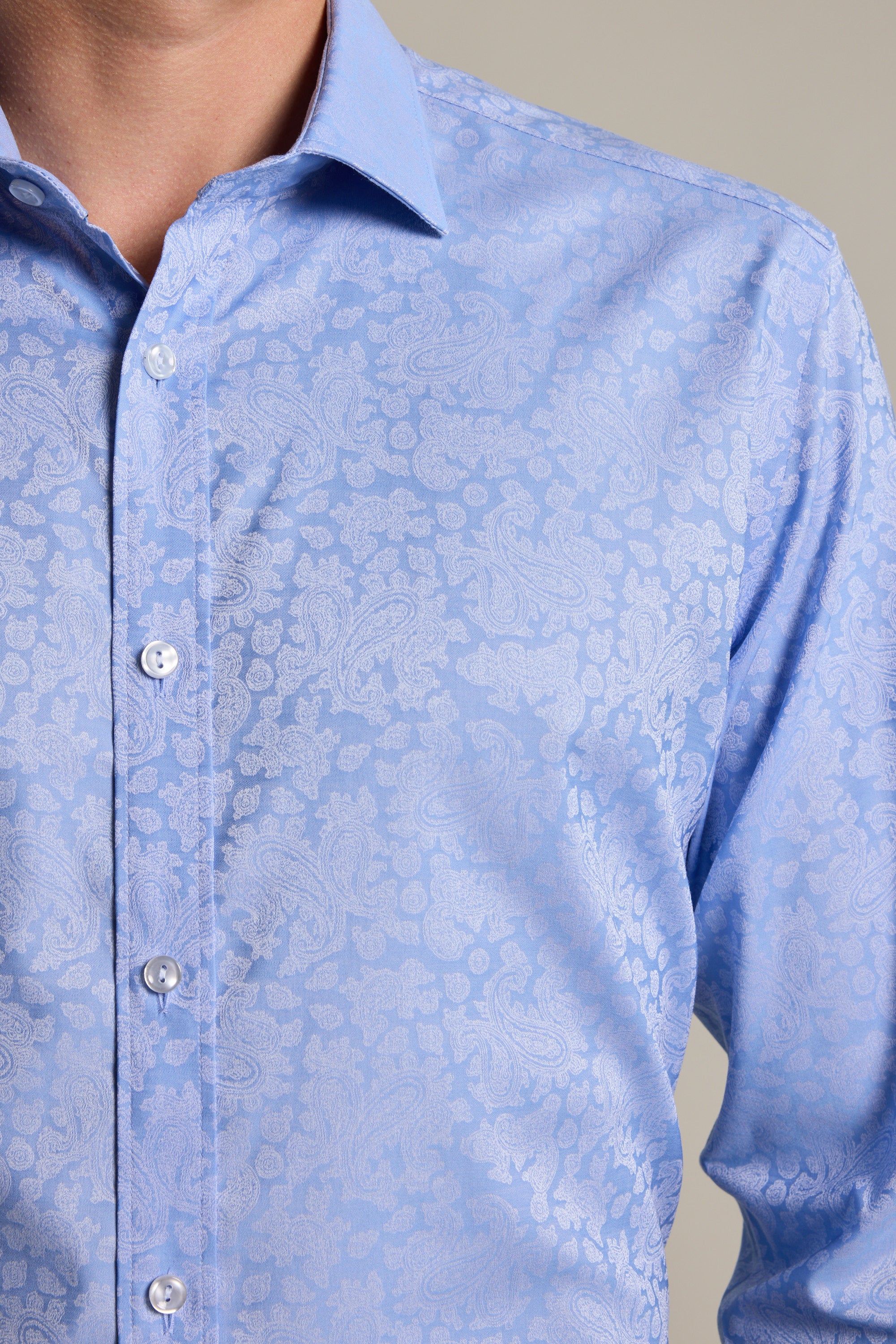 A close-up of a person wearing the Barkers Corran Paisley Business Shirt, featuring a light blue subtle paisley pattern and tailored fit, buttoned to the collar and showcasing only the neck and upper torso.