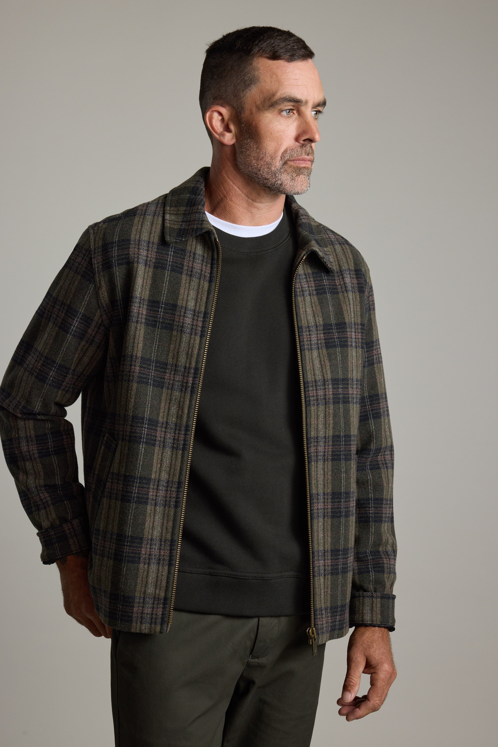 Man in Barkers Zermatt Wool Jacket over dark shirt and pants, looking to the side.