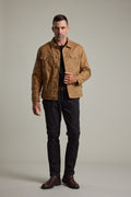 Man wearing the Barkers Benson Waxed Cotton Sherpa Jacket, black shirt, pants, and brown boots.