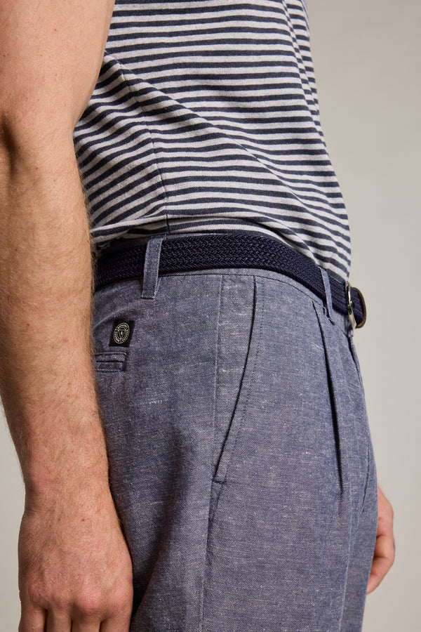 A person wears blue Barkers Newman Linen Pants with a gray and white striped short-sleeve shirt and navy braided belt, seen from the side at waist height for a smart-casual look.