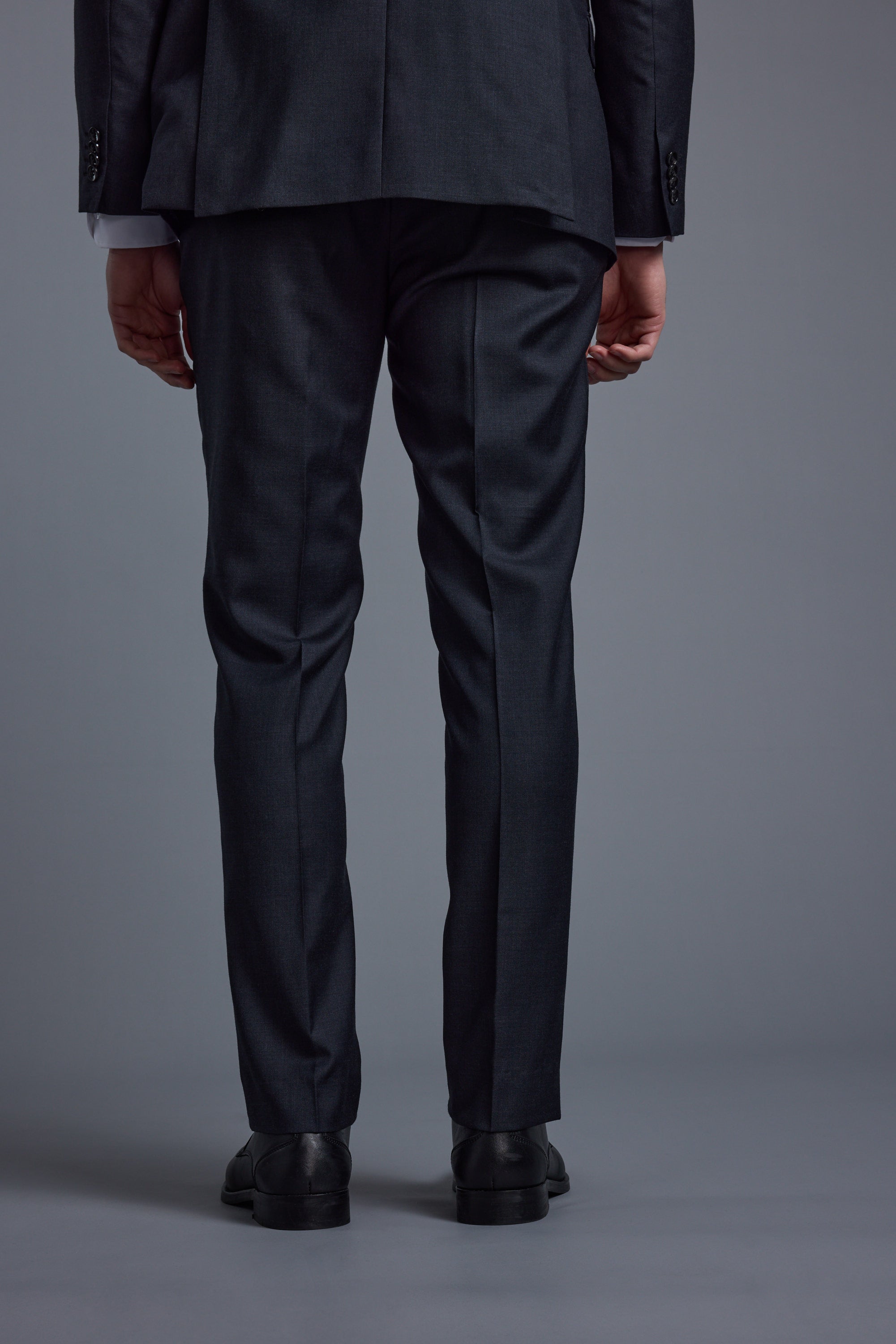 A person models the Barkers Mayfair ZQ Suit Trouser, shown from the lower back down with black shoes, standing against a plain gray background.