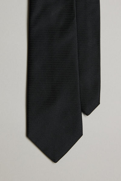 A close-up of the Barkers Black Tie features its subtle jacquard print on the bottom ends, set against a light gray background.