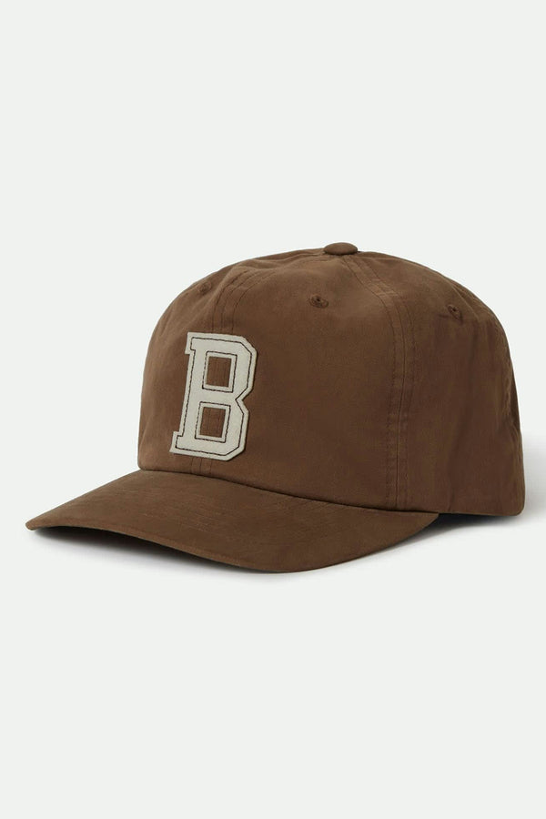 The Brixton Big B MP Cap by Brixton is a brown 6-panel cotton corduroy baseball cap with a large white "B" on the front and an adjustable leather strap, shown against a plain light background.