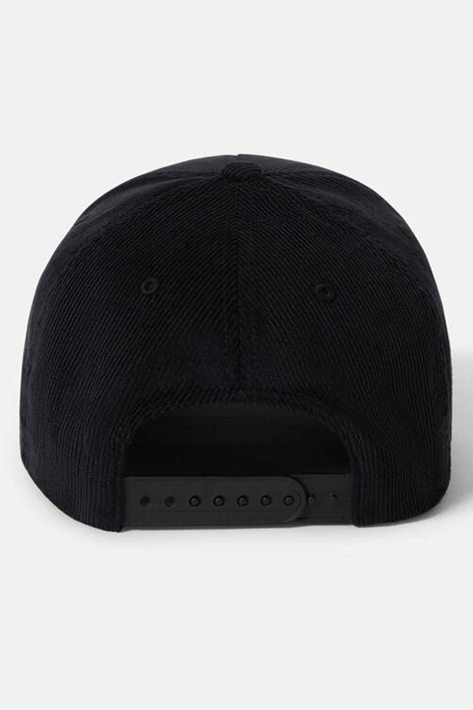 A black Brixton Pierson Snapback by Brixton is shown from the back, highlighting its cotton corduroy finish and adjustable snapback closure. The background is plain light grey.