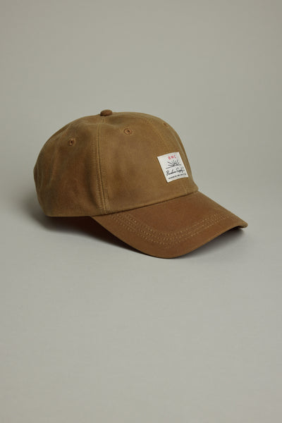 Barkers Benson Waxed Cotton Cap—brown, adjustable fit, white patch, on gray background.