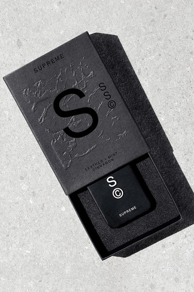 Black Solid State - Supreme box with branded cologne on gray surface.