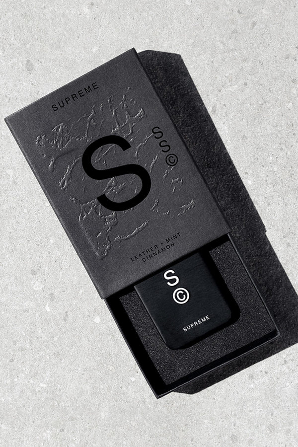 Black Solid State - Supreme box with branded cologne on gray surface.